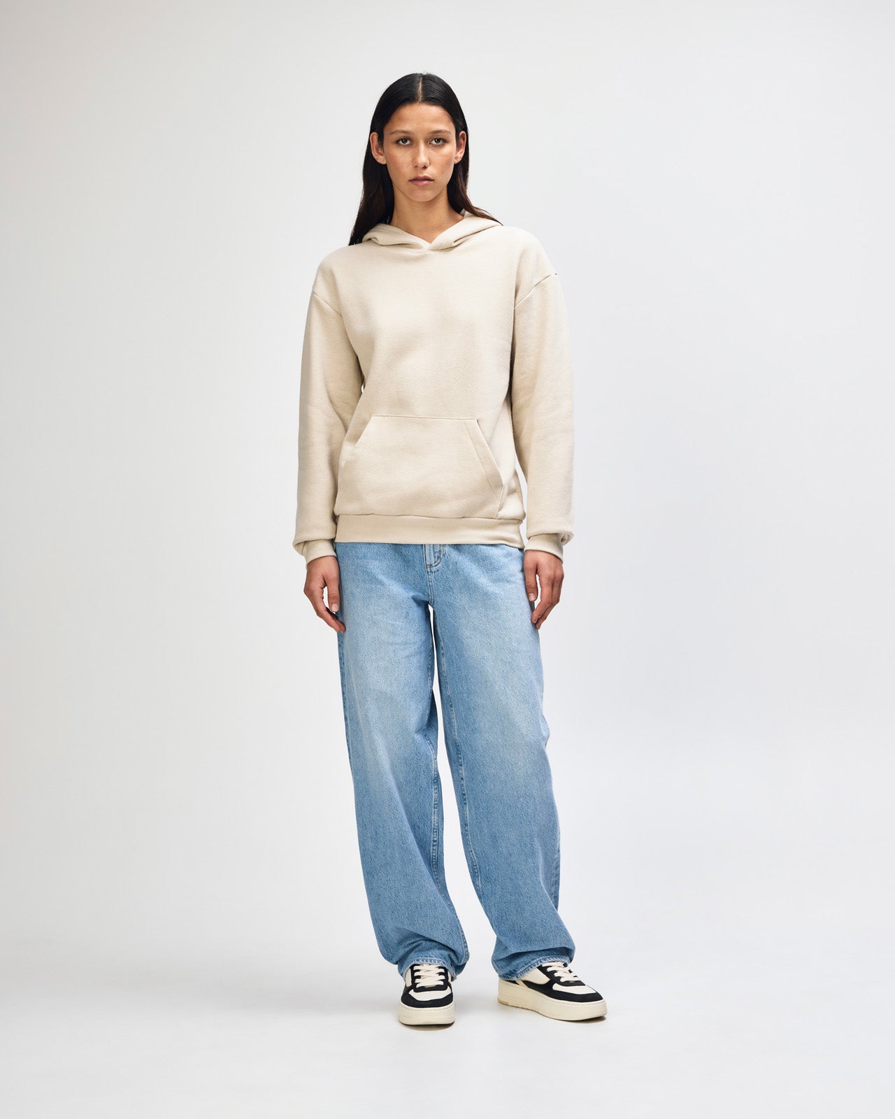 Female model wearing a Reflex Unisex Hooded Sweatshirt (front pose) -bone