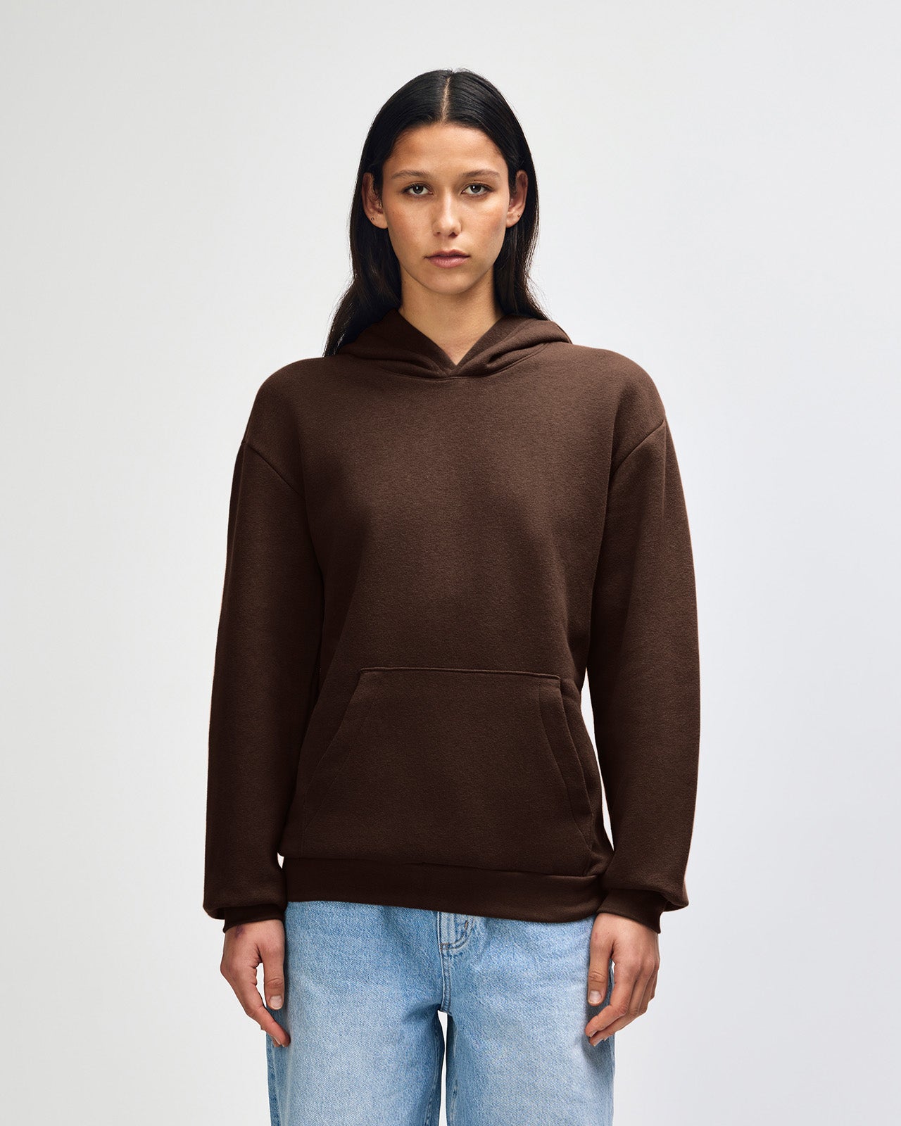 Female model wearing a Reflex Unisex Hooded Sweatshirt (front pose) -Brown