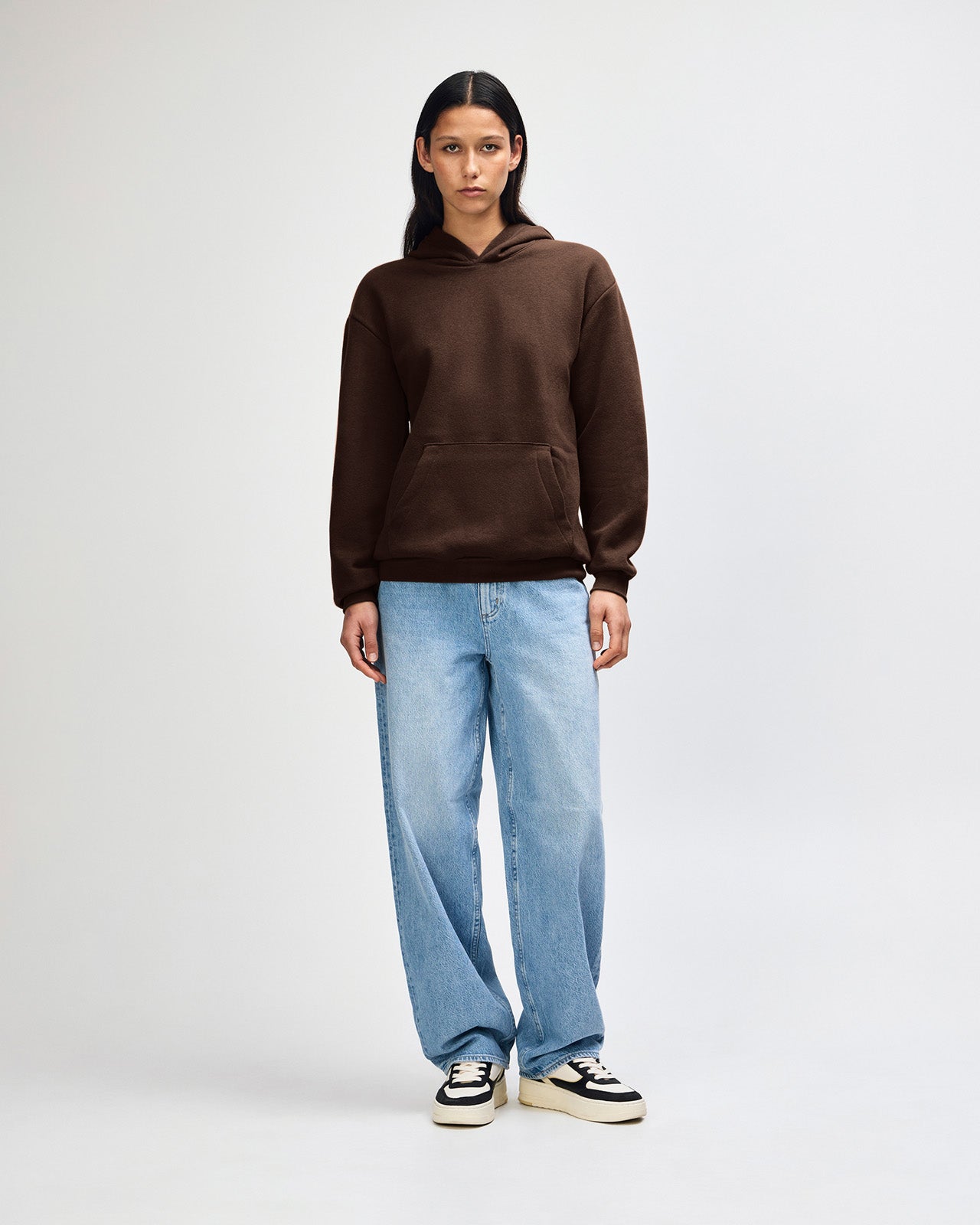 Female model wearing a Reflex Unisex Hooded Sweatshirt (front pose) -Brown