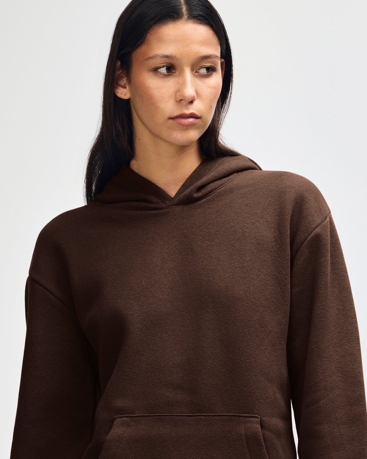 Female model wearing a Reflex Unisex Hooded Sweatshirt (front pose) -Brown