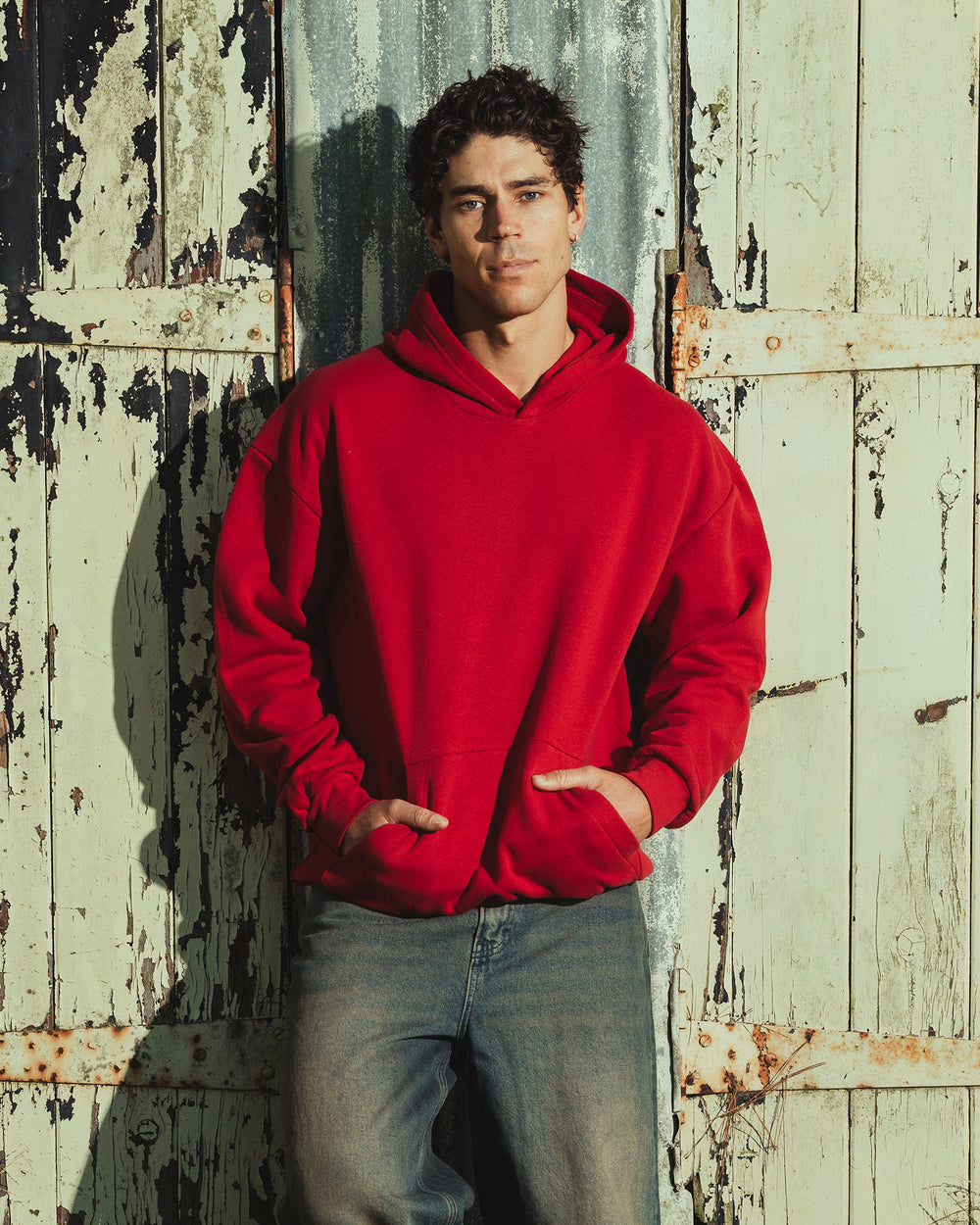 image of Unisex Hoodie : Male model wearing a Reflex Unisex Hooded Sweatshirt (front pose) -cardinal red