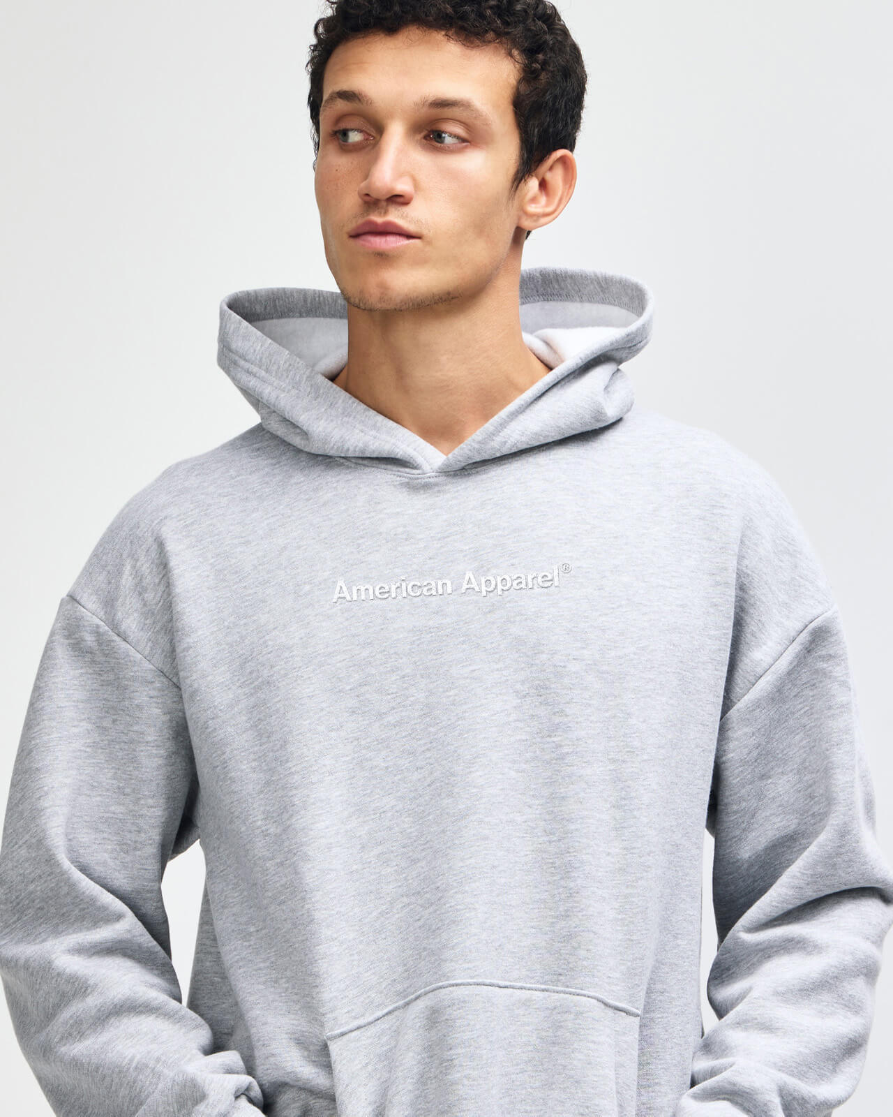 Man wearing a gray hoodie against a plain background -Heather Grey