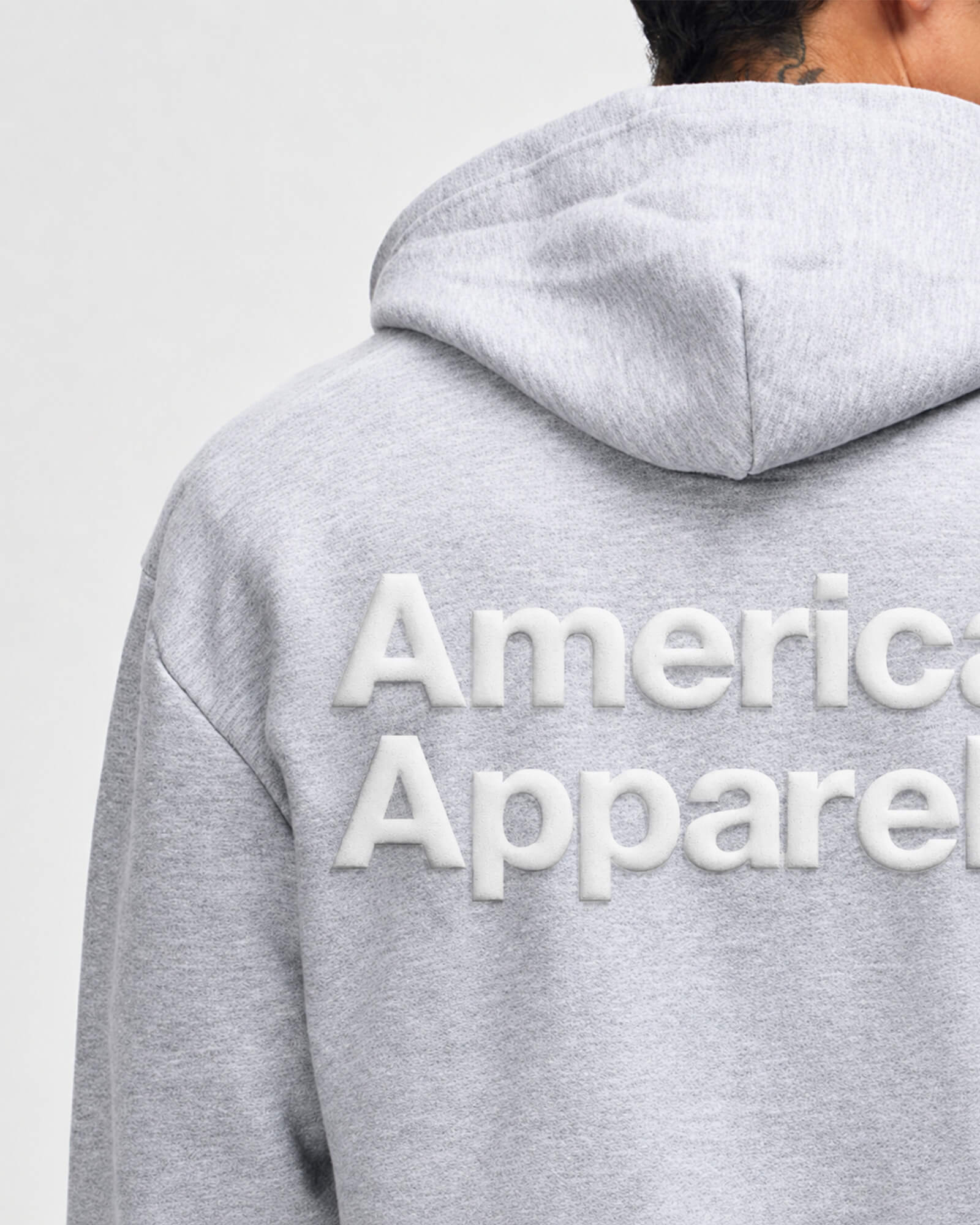 Gray hoodie with 'American Apparel' logo on the back against a light gray background -Heather Grey