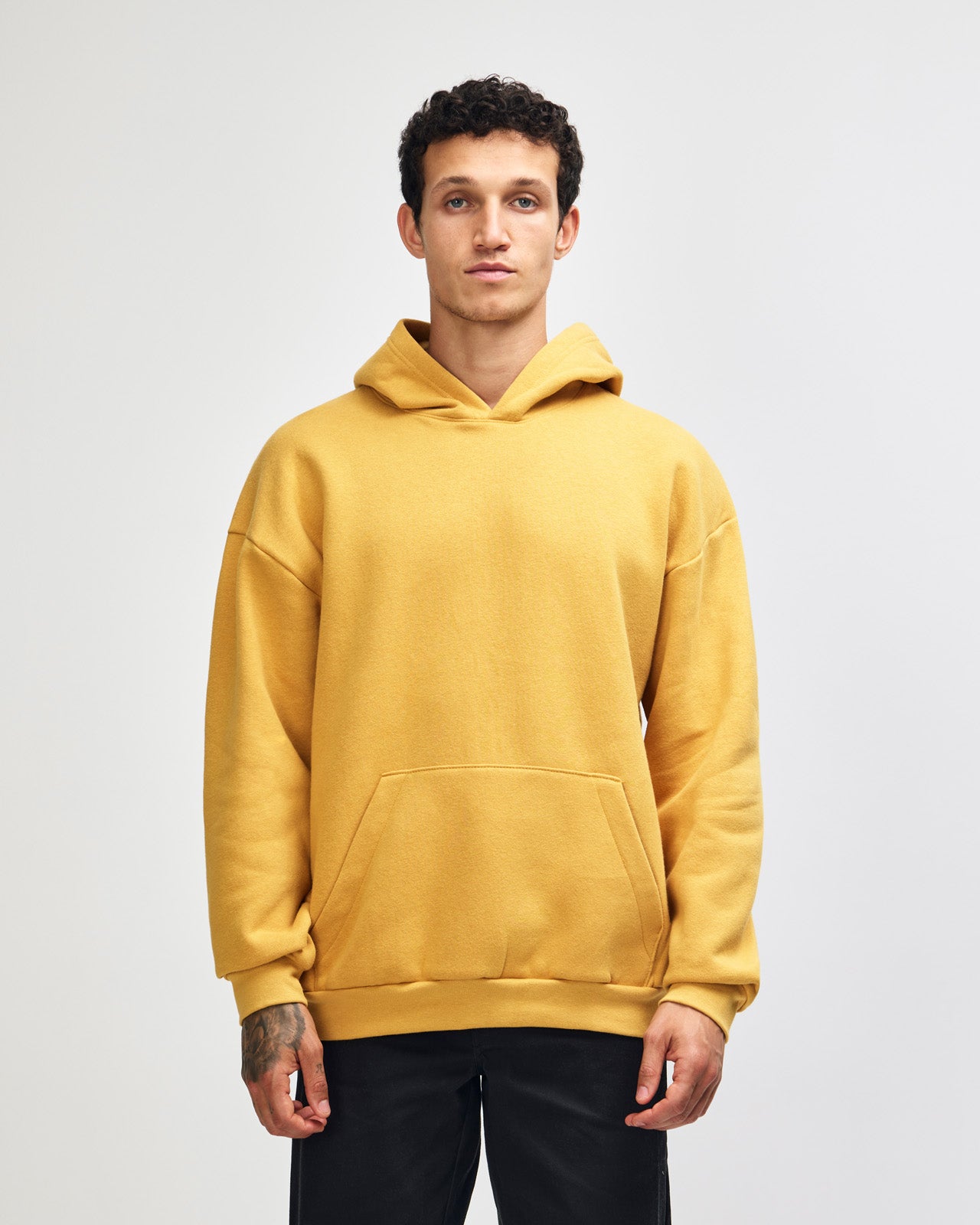Male model wearing a Reflex Unisex Hooded Sweatshirt (front pose) -mustard