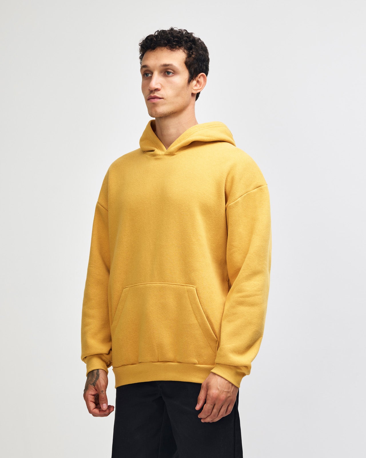Male model wearing a Reflex Unisex Hooded Sweatshirt (front pose) -mustard