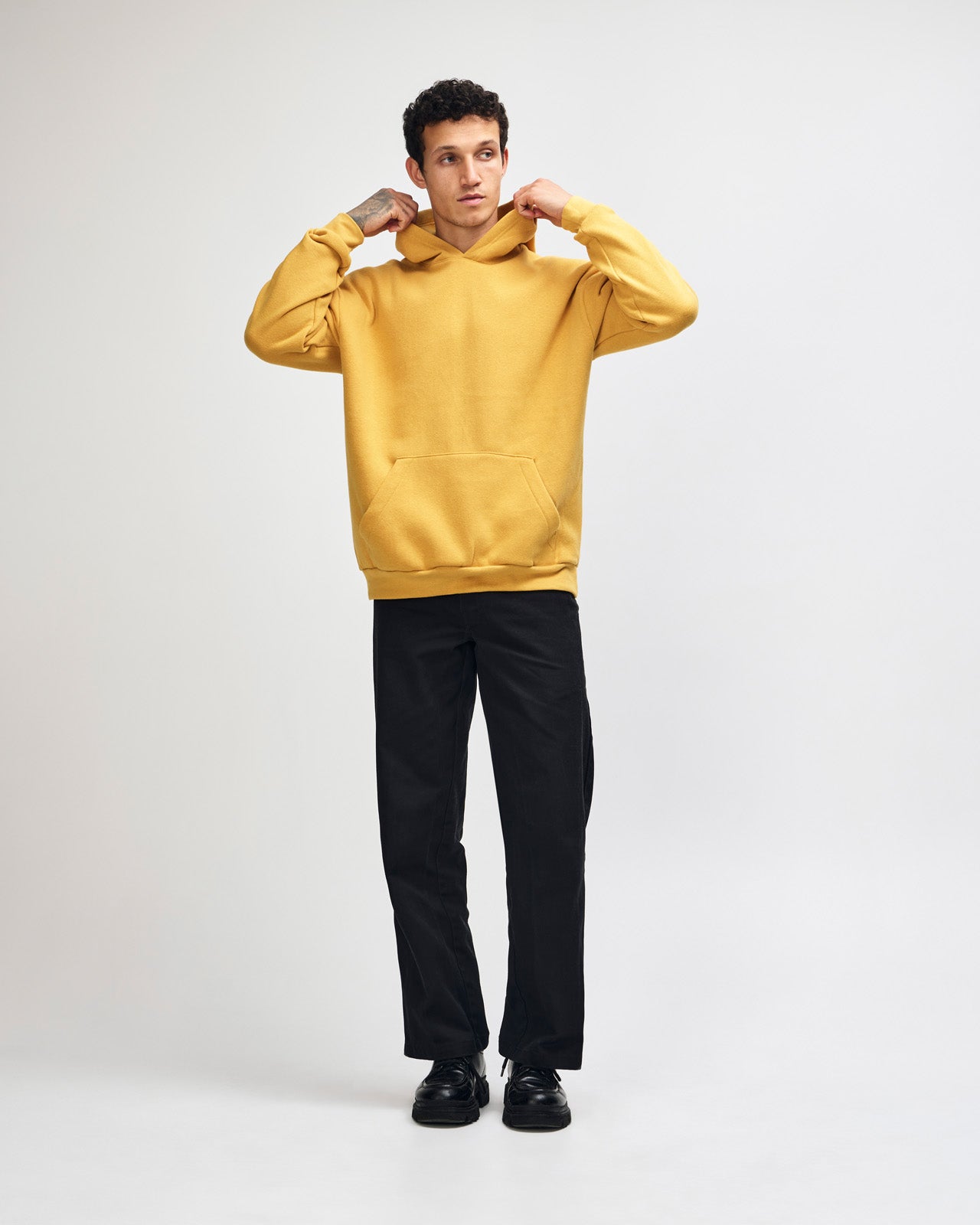 Male model wearing a Reflex Unisex Hooded Sweatshirt (front pose) -mustard