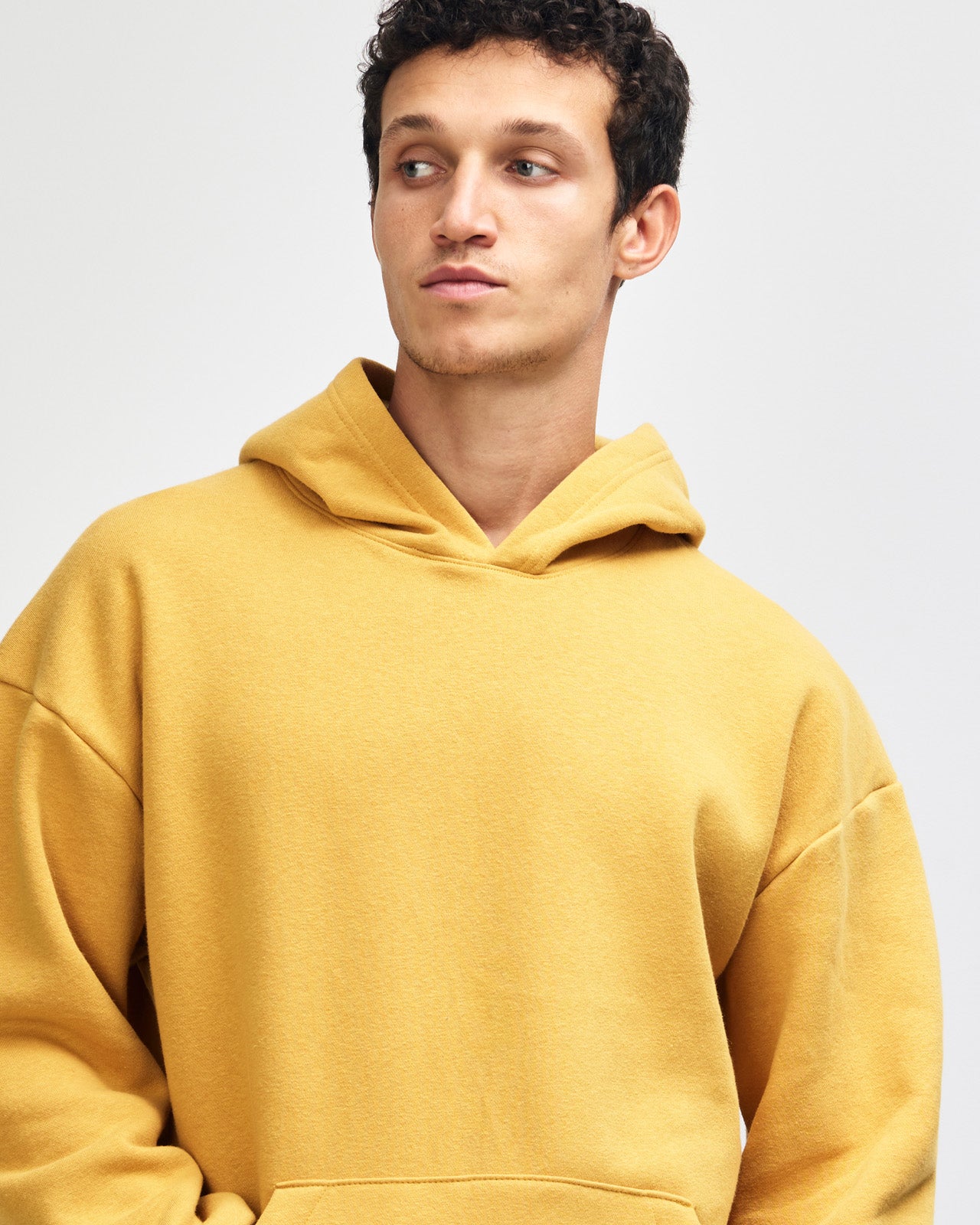 Male model wearing a Reflex Unisex Hooded Sweatshirt (front pose) -mustard